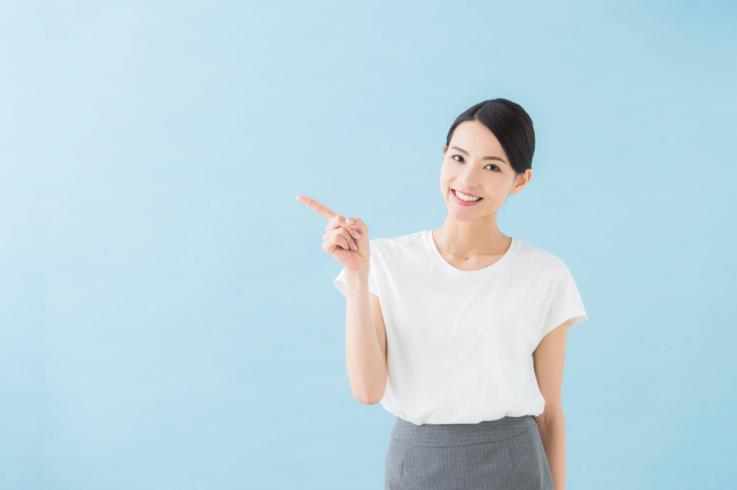 右方向を指差す女性の写真